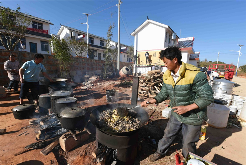 1月23日,禄劝彝族苗族自治县洗马塘村的龙绍聪在做美食招待来祝贺他家